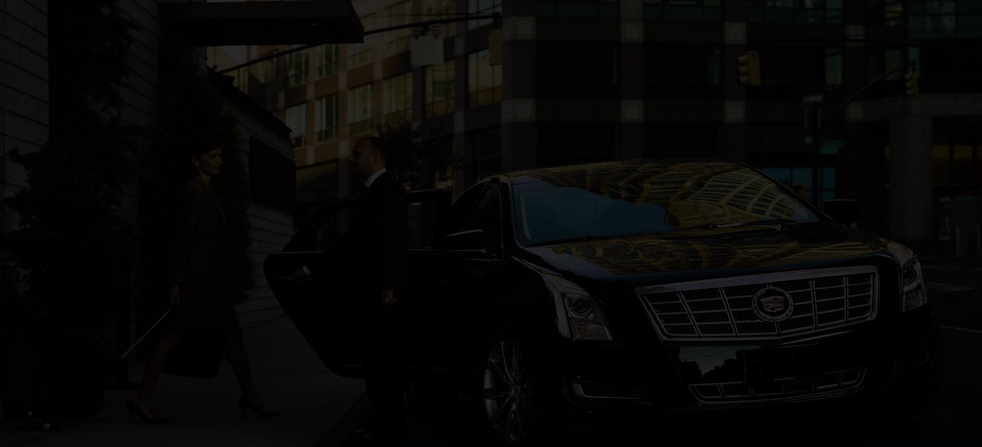 Front of a black Cadillac sedan in low light