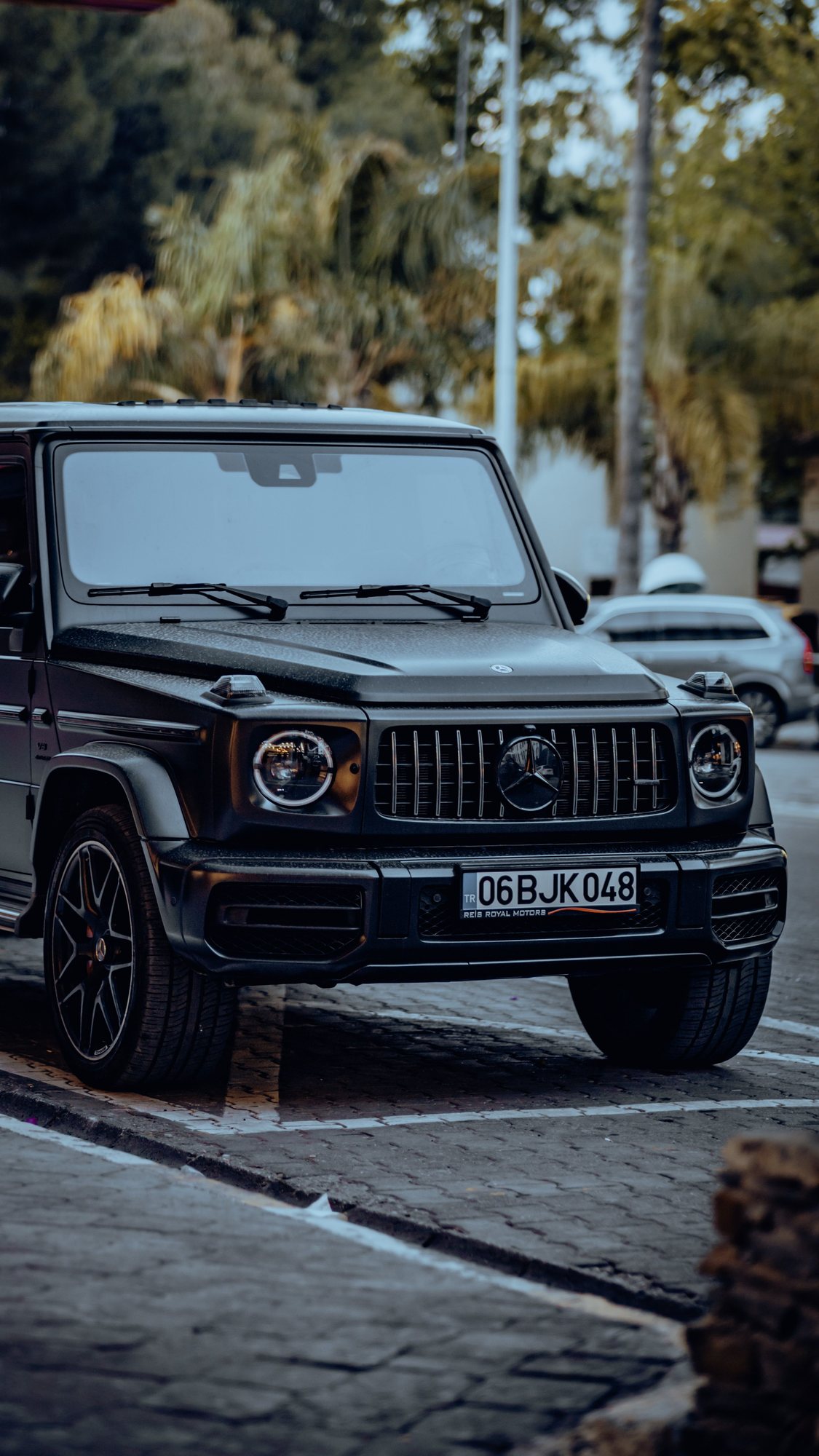 A black Mercedes-Benz SUV parked along an urban street.