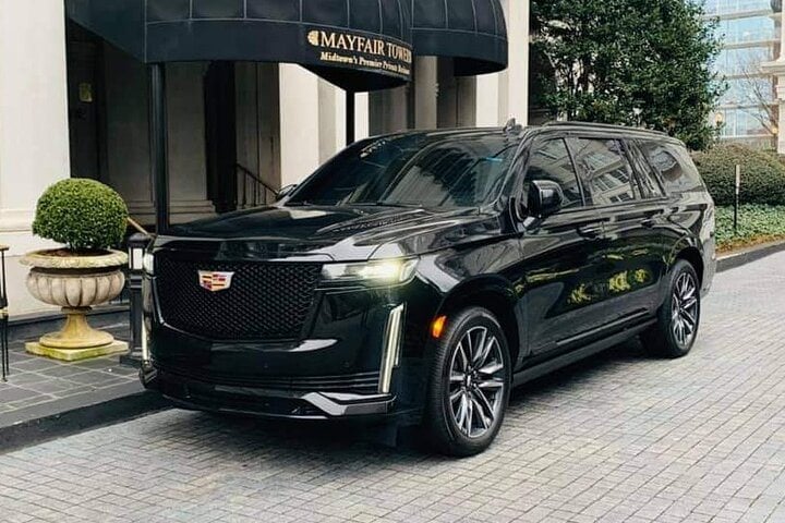 Black Executive Transportation SUV waiting under the awning at a hotel entrance