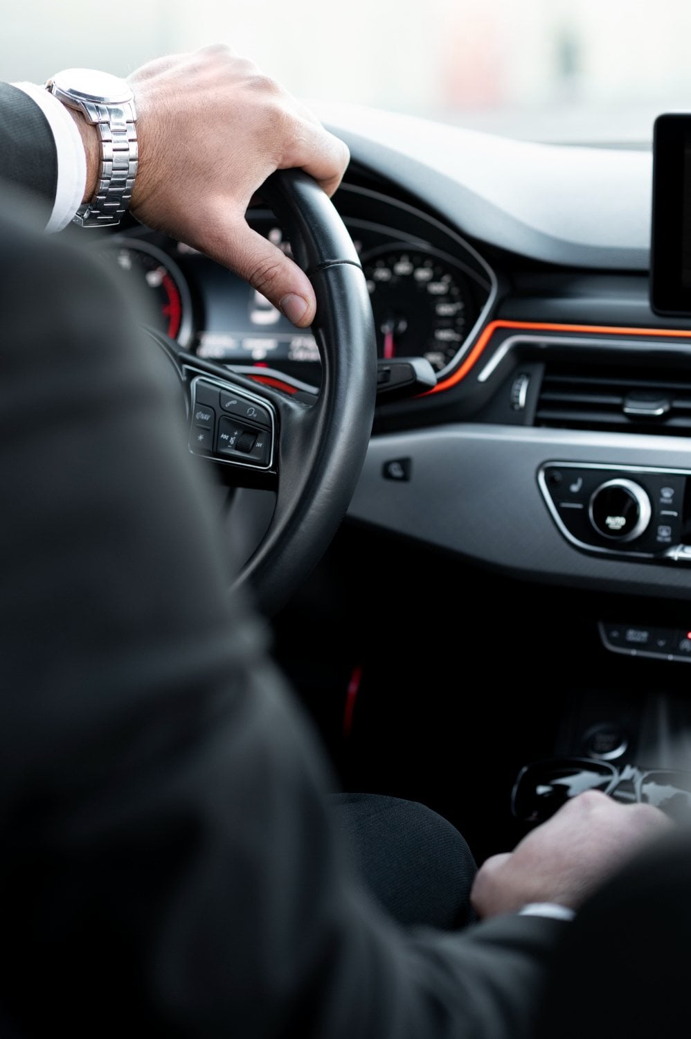 Uniformed Executive Transportation chauffeur at the wheel with both hands on it