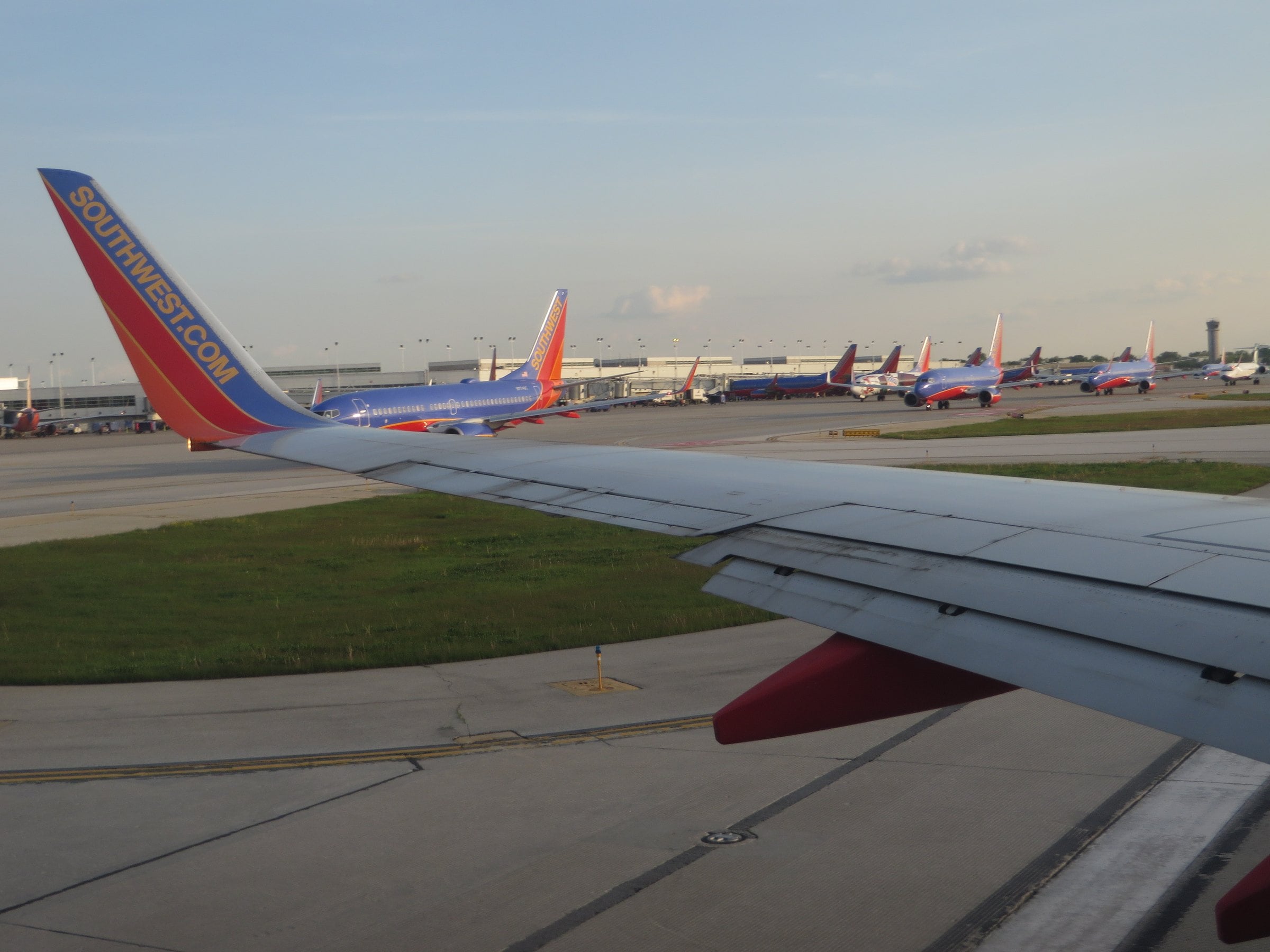 Airliners lined up on the ramp along the terminal at Chicago Midway International Airport under a pale sky