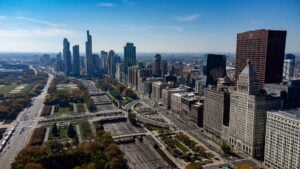 The downtown Chicago skyline rising beyond parkland and roadway, seen from the South Loop.