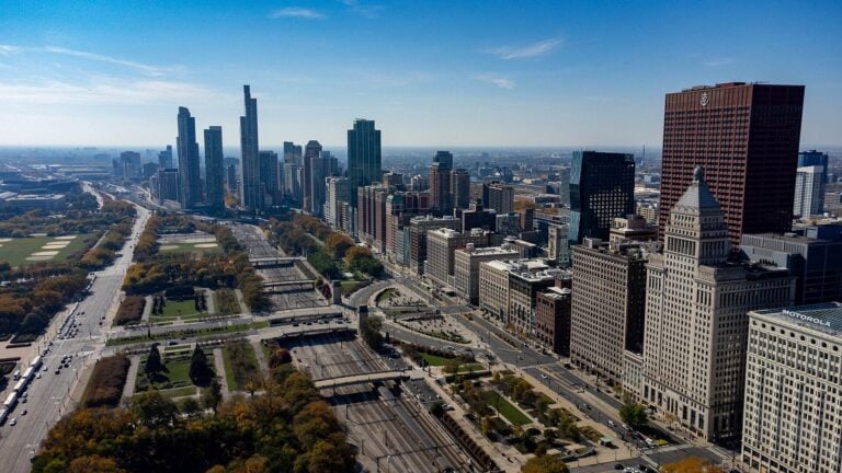 The downtown Chicago skyline rising beyond parkland and roadway, seen from the South Loop.