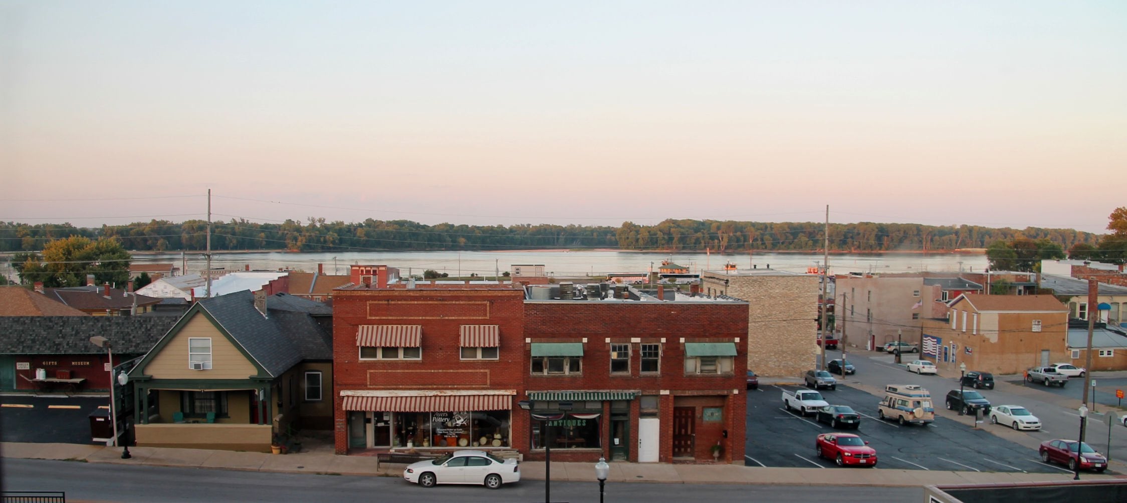 Downtown Hannibal, Missouri, at dusk with the Mississippi River behind the storefronts