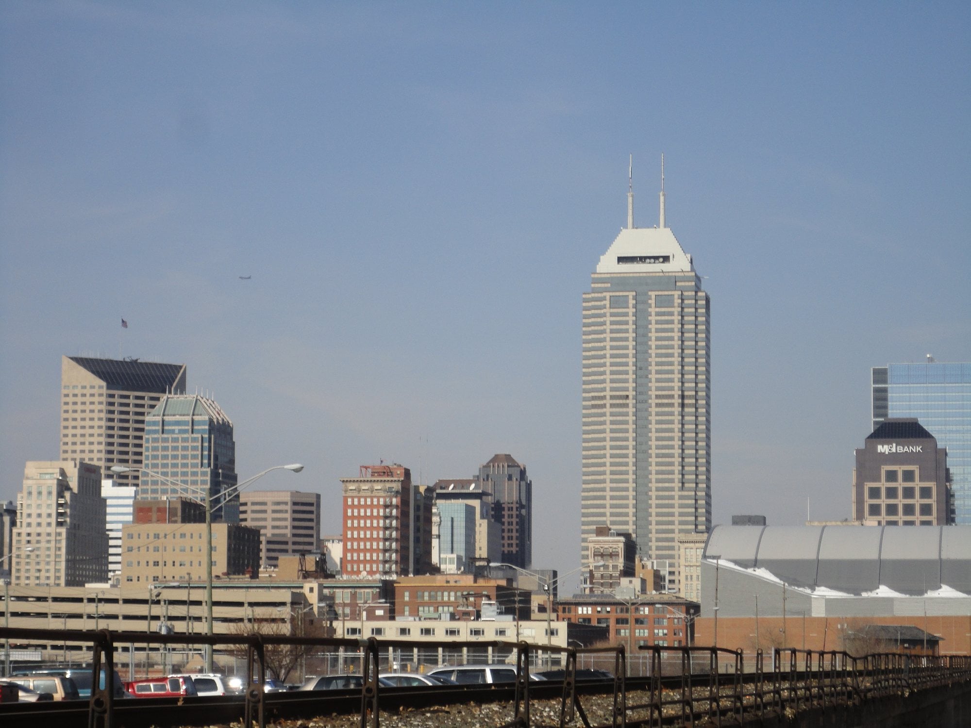 The downtown Indianapolis skyline rising behind elevated railroad tracks
