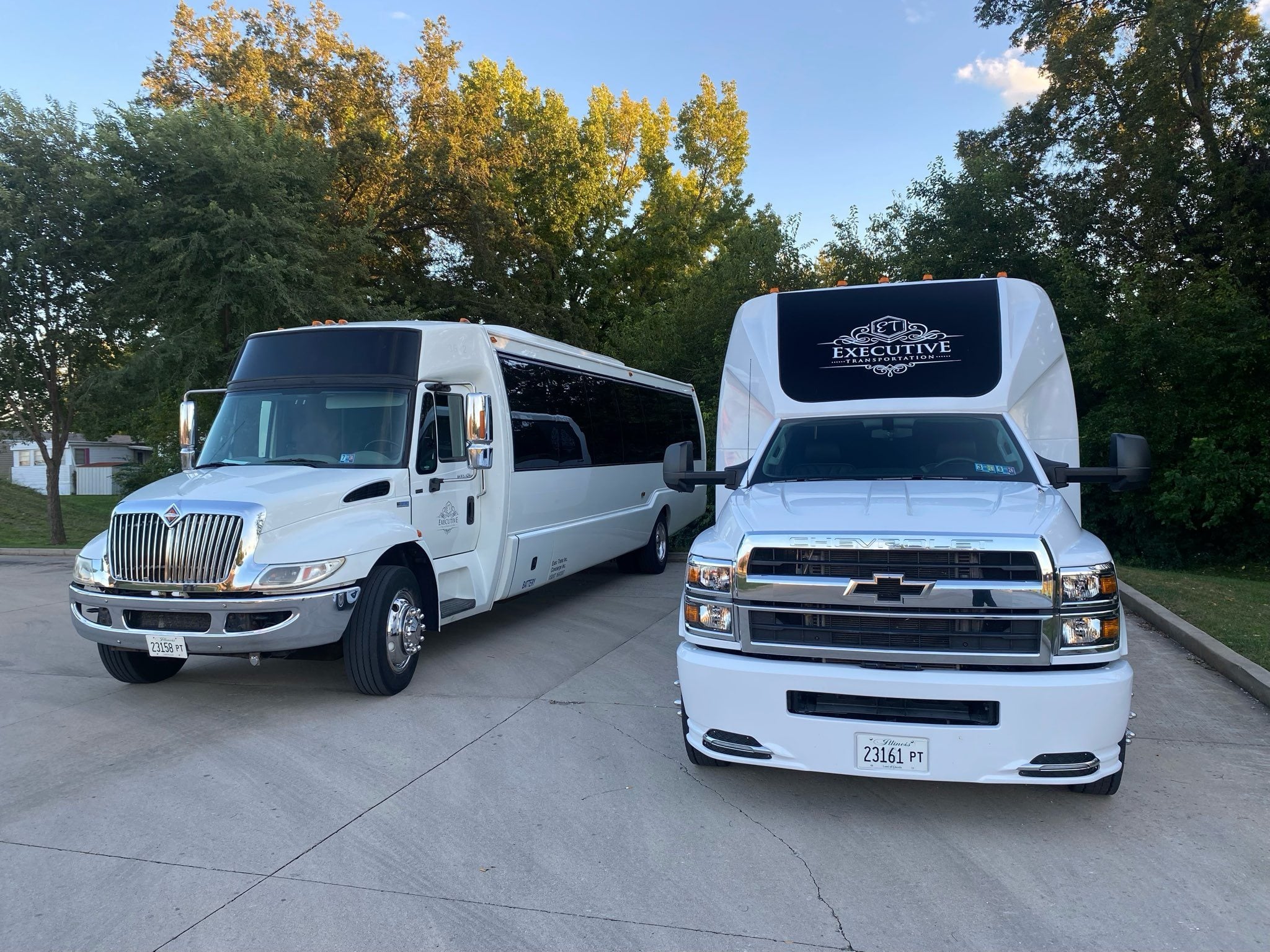 Two white Executive Transportation shuttle coaches waiting to run a scheduled loop for one group