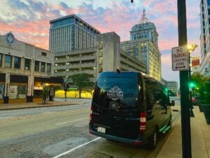 Black Executive Transportation Sprinter van on a downtown street at sunset