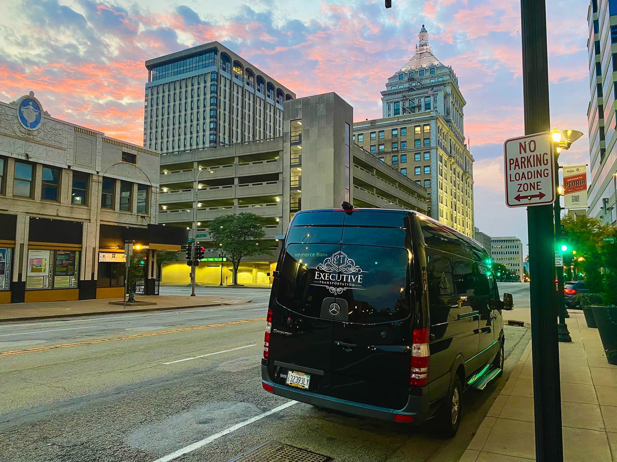Black Executive Transportation Sprinter van on a downtown street at sunset