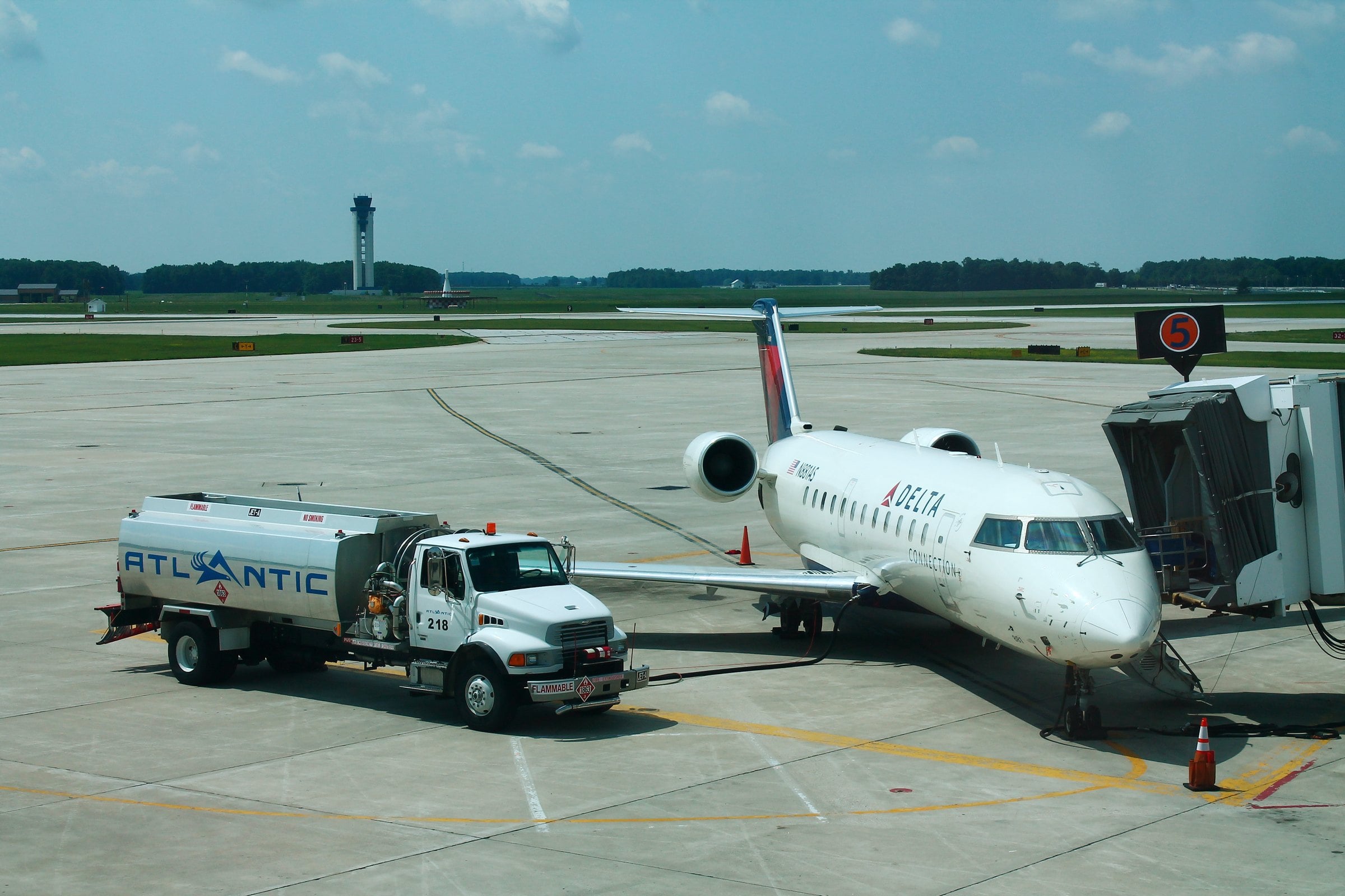 Regional jet at a jet bridge gate at Fort Wayne International Airport with the control tower behind it