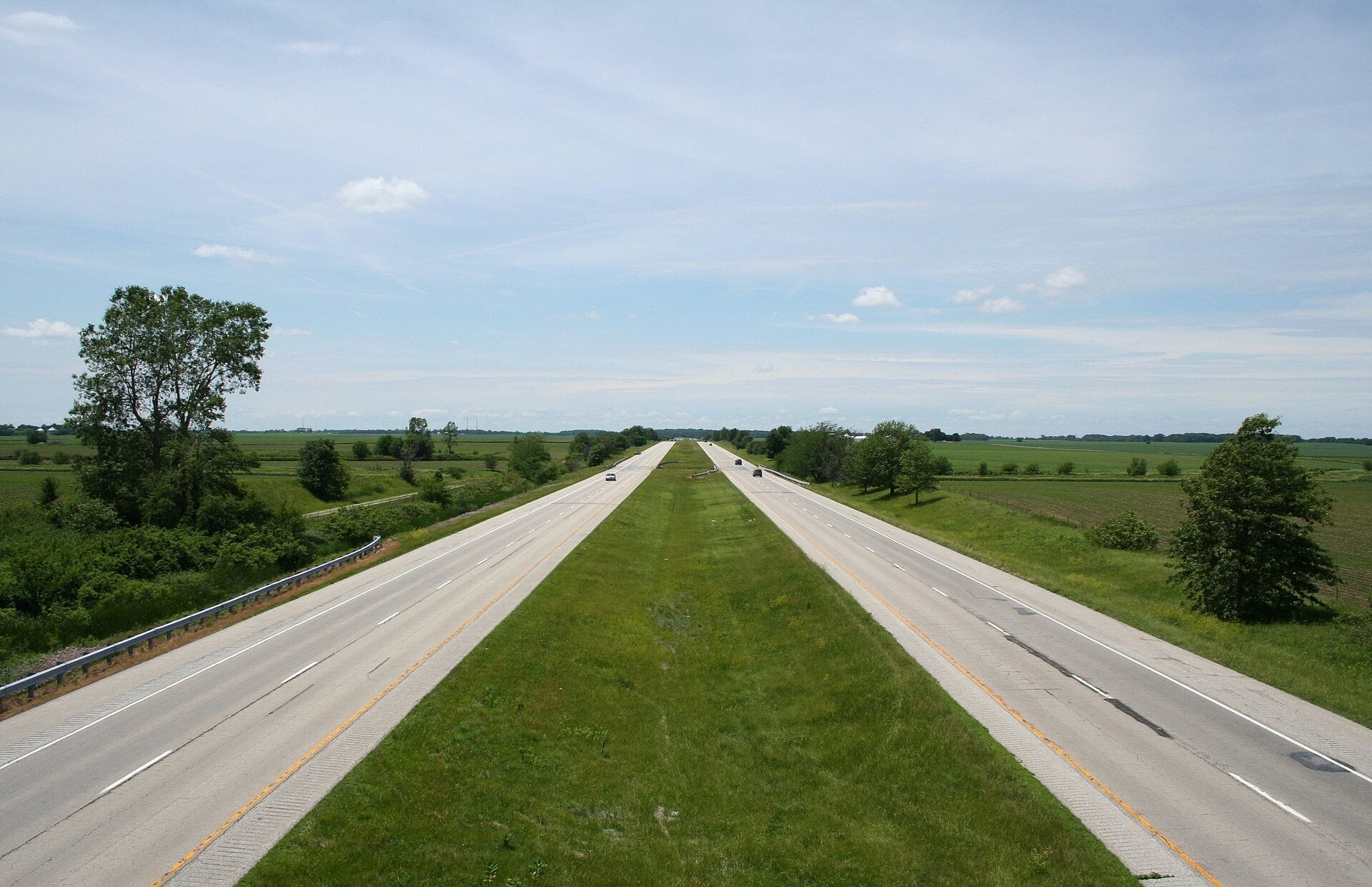 Empty lanes of Interstate 72 running straight through green Illinois farmland.