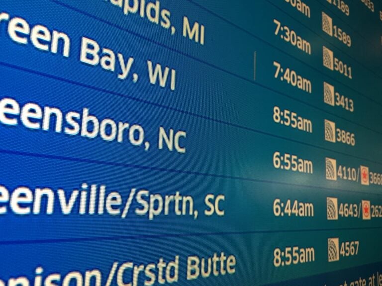 A departures board at Chicago O'Hare International Airport listing morning flight times and destinations