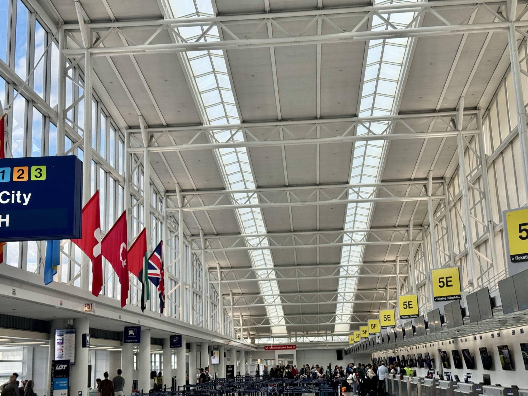 Airline check-in counters and national flags in the Terminal 5 entrance hall at Chicago O'Hare International Airport
