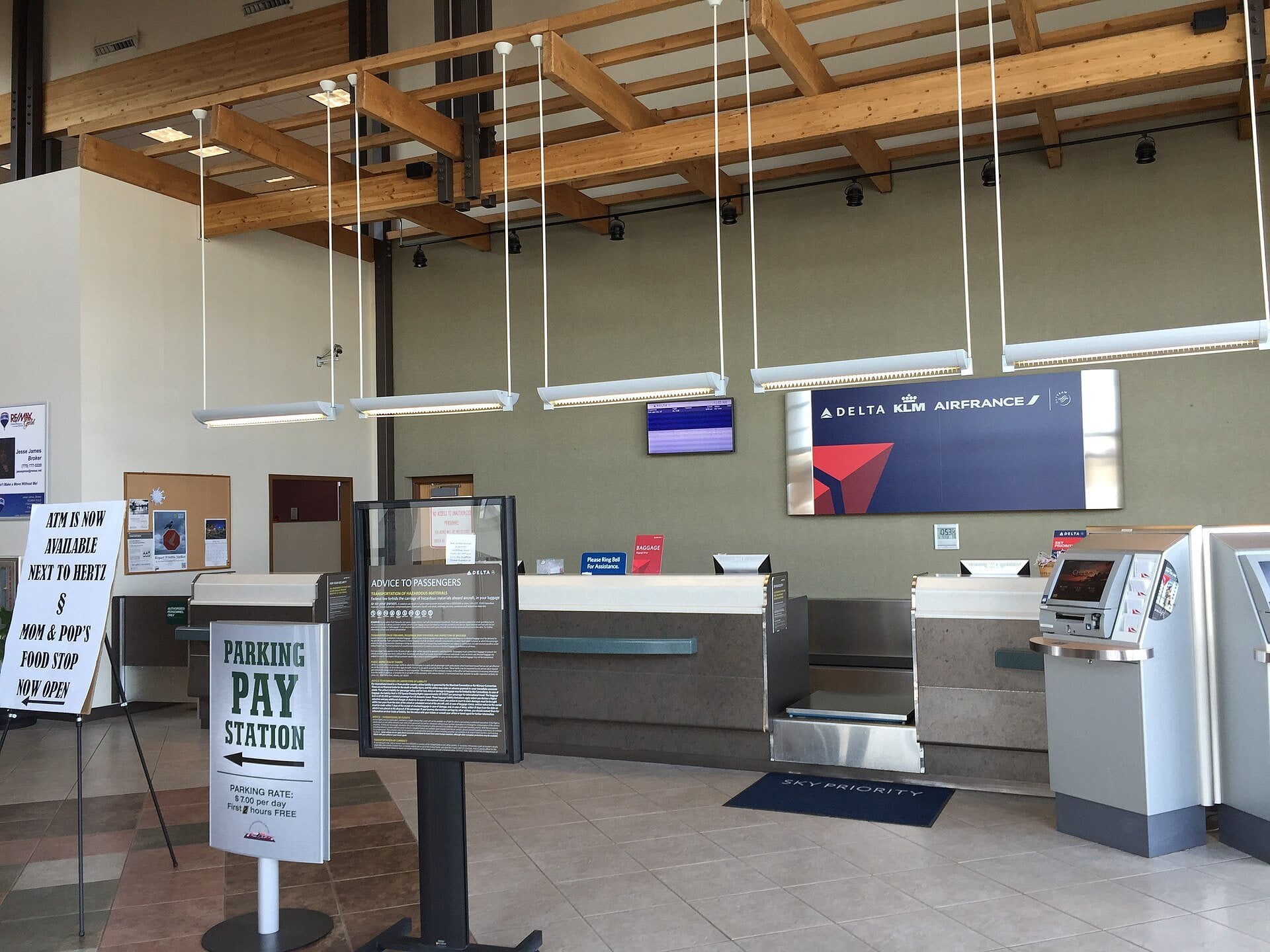 Empty ticketing and check-in counters inside a small regional airport terminal.