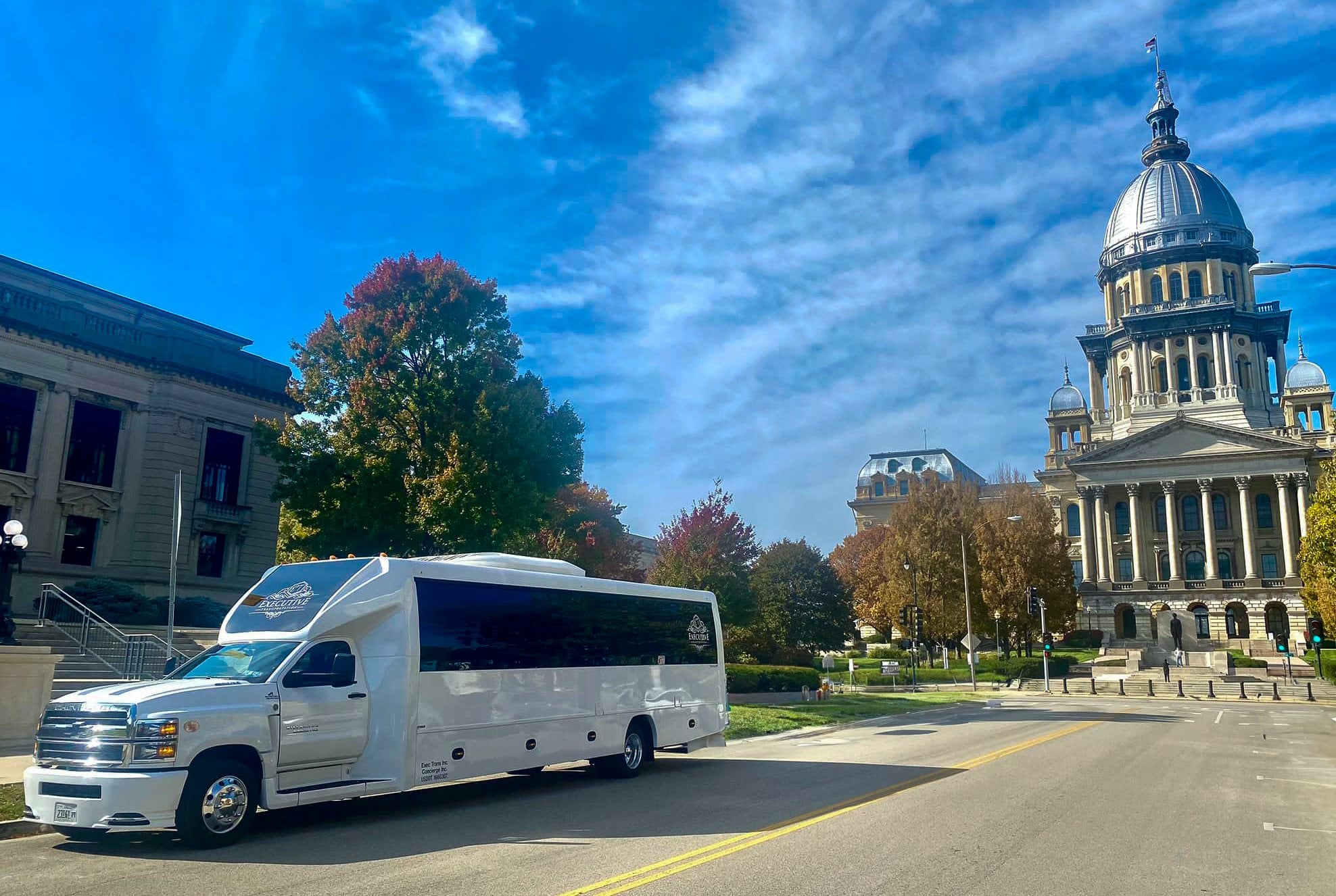 White Executive Transportation shuttle coach standing near the Illinois State Capitol between loop departures