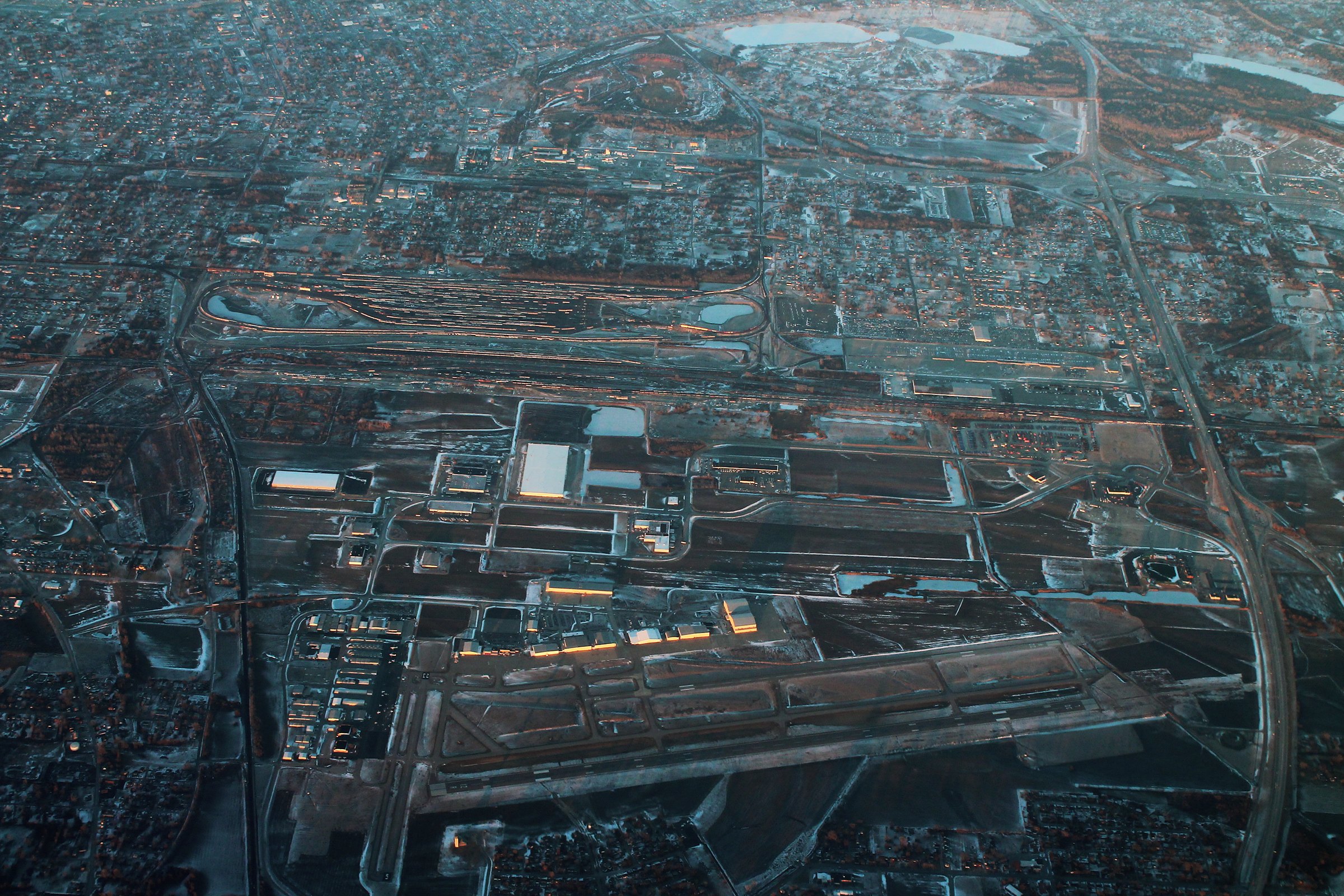 Aerial view of St. Louis Downtown Airport and its runways at dusk, with the lights of Cahokia and the rail yards around it