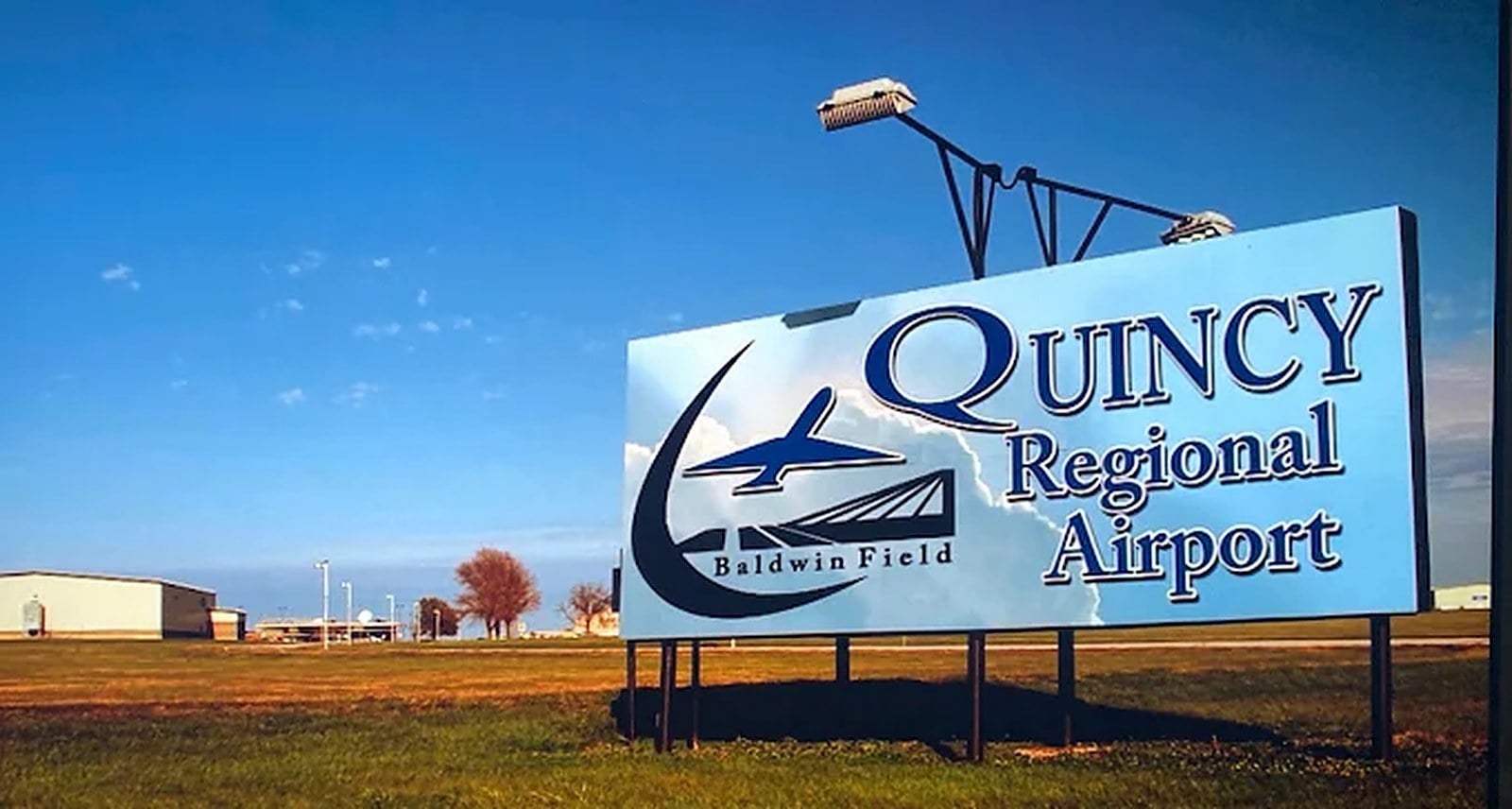 Quincy Regional Airport Baldwin Field entrance sign against a blue sky