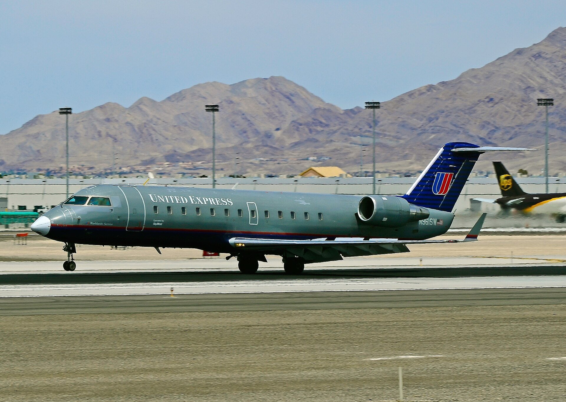 A United Express CRJ-200 regional jet parked on an airport ramp.